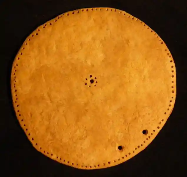 Clay solar disc with solar symbol composed of dots